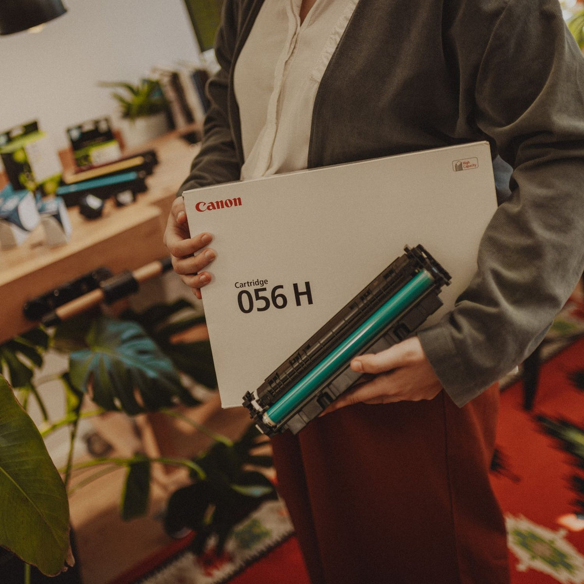 Person hält eine Tonerschachtel von Canon sowie eine Tonerkartusche in den Händen